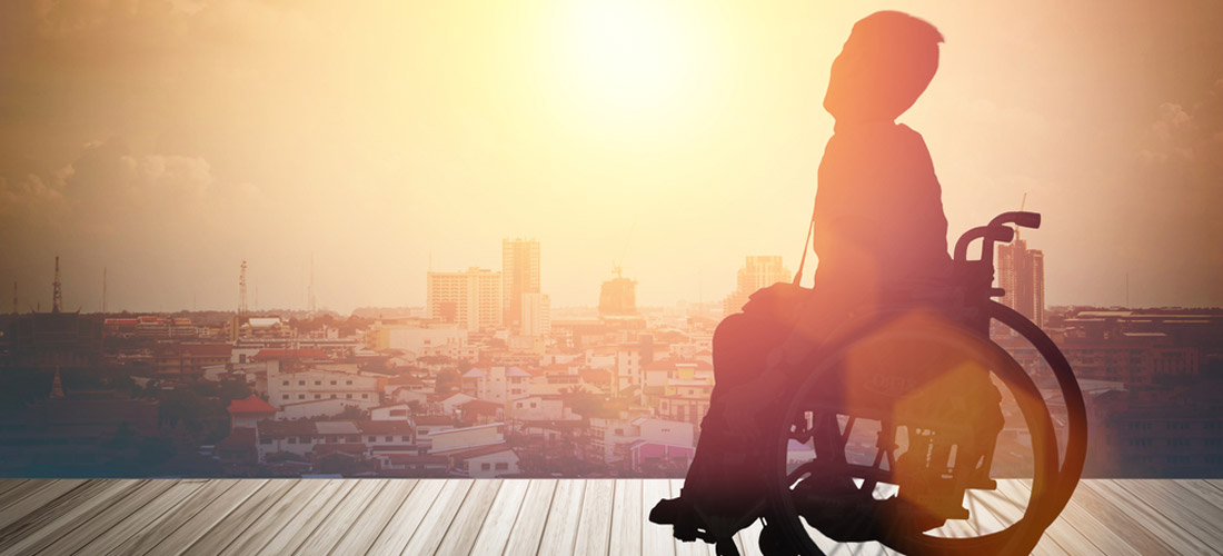 Im Vordergund ein Mädchen, das im Rollstuhl sitzt, im Hintergrund sieht man die Silhouette einer Stadt