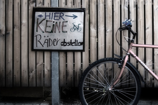 Das Foto zeigt ein Fahrrad vor einem Schild, auf dem 'Hier keine Räder abstellen' steht.